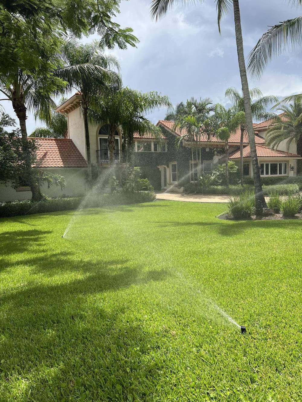 Residential irrigation system running across a healthy South Florida lawn